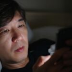 深夜にベッドの中でスマートフォンを見ている様子。